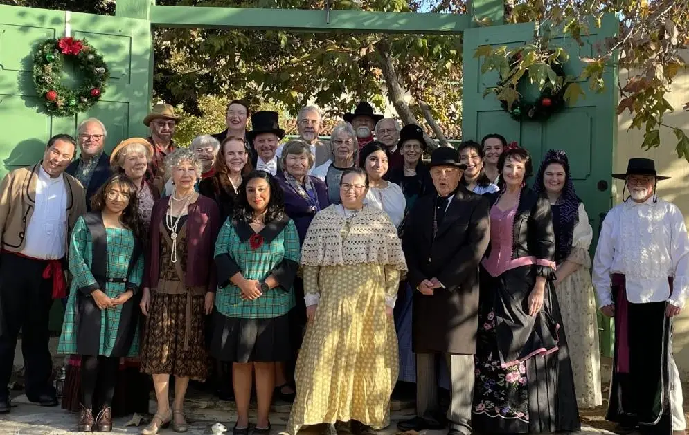 Group in historical costumes in front of gate