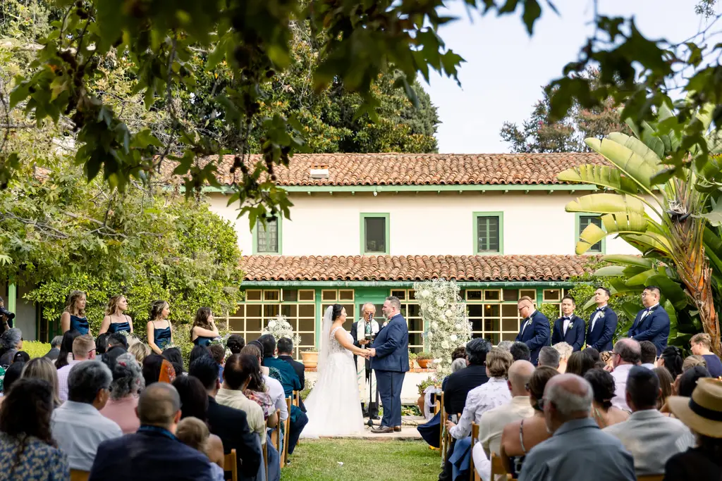 Outdoor wedding ceremony with guests seated.