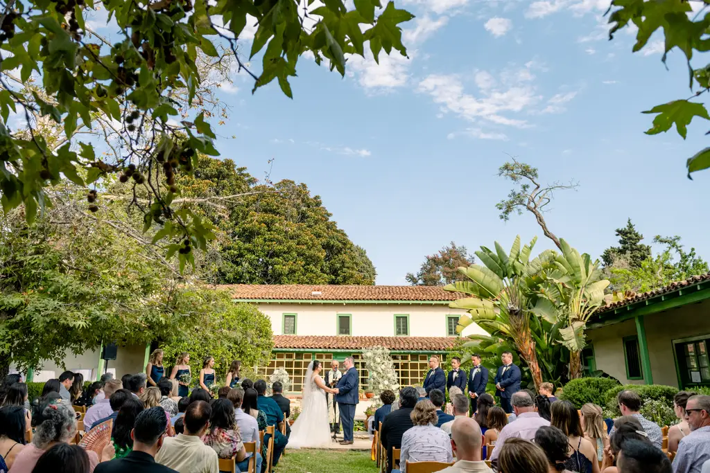 Outdoor wedding ceremony in a garden setting.