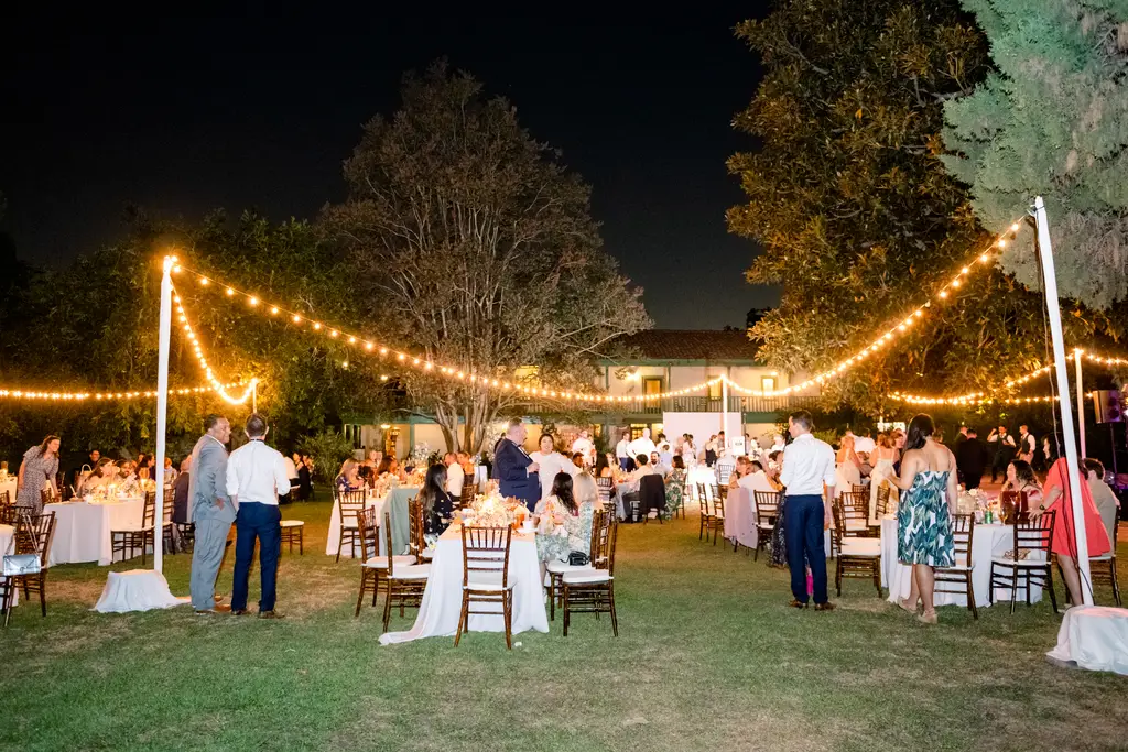 Outdoor evening wedding reception with string lights