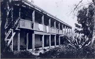 Historic two-story wooden house with porch.