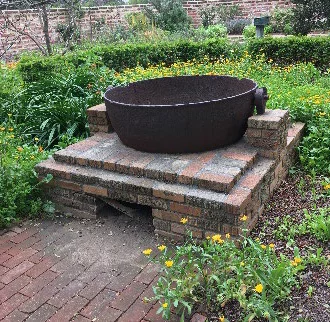 Historic outdoor brick oven in garden setting.