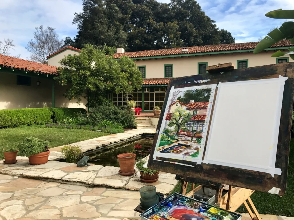 Outdoor painting of garden scene on easel.